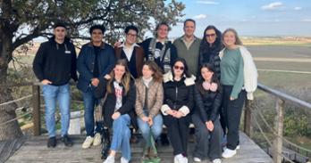 Student tour group with the fields of Troy behind them