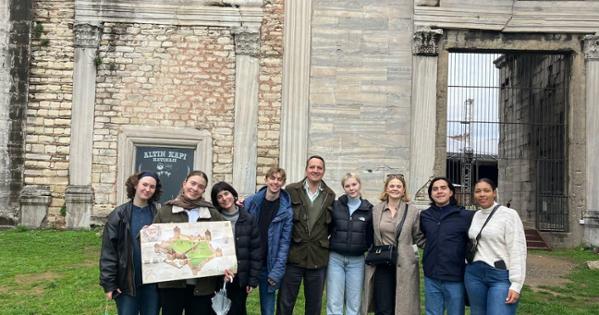 Tour group at the Yedikule Fortress, with the building's rough and smooth stone walls in shades of gray.