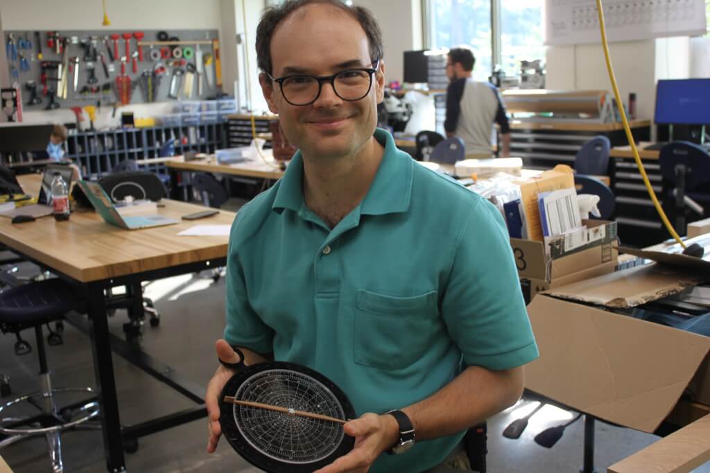 Michael Robinson holding his laser-cut astrolabe