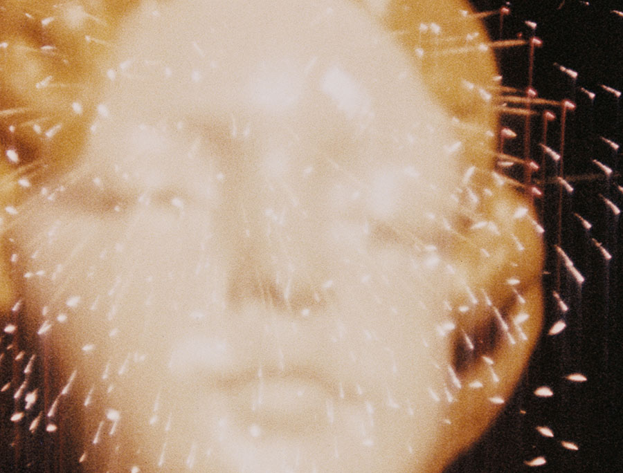 LOOKING FOR MUSHROOMS 1959-67/1996. Film still of a woman's face superimposed with fireworks