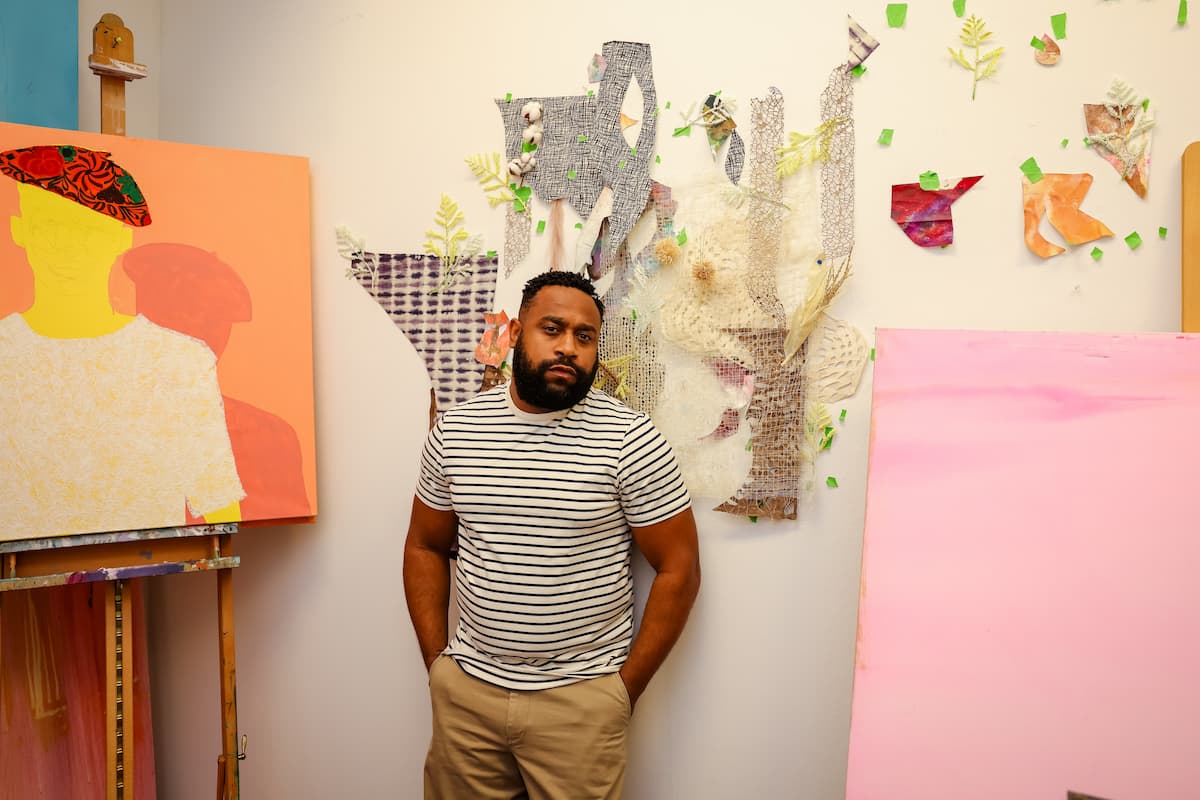 Charles Jean-Pierre in front of multimedia collage on wall