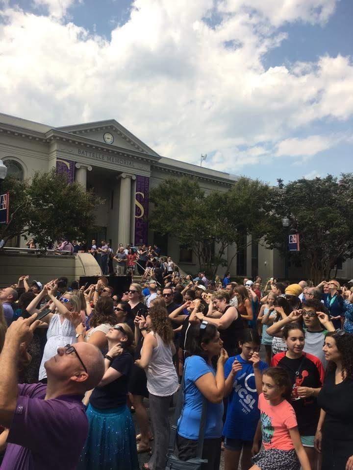 AU eclipse viewing party gazes up at sky through eclipse glasses and cell phones