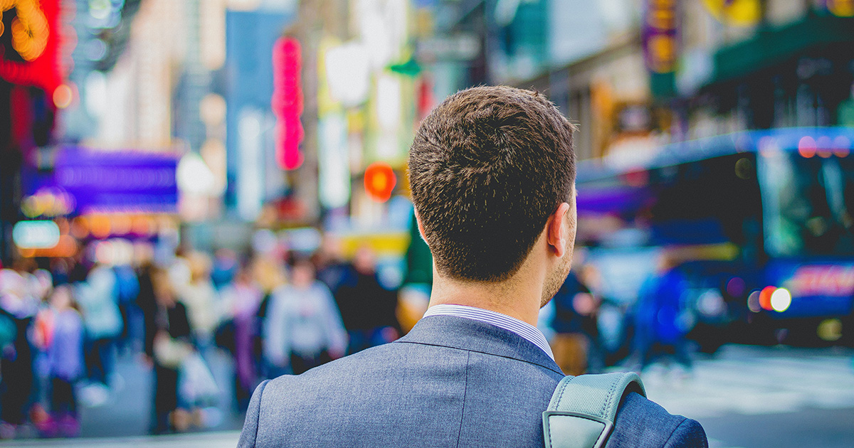 A person in a suit walking in the street.  Photo by Saulo Mohana