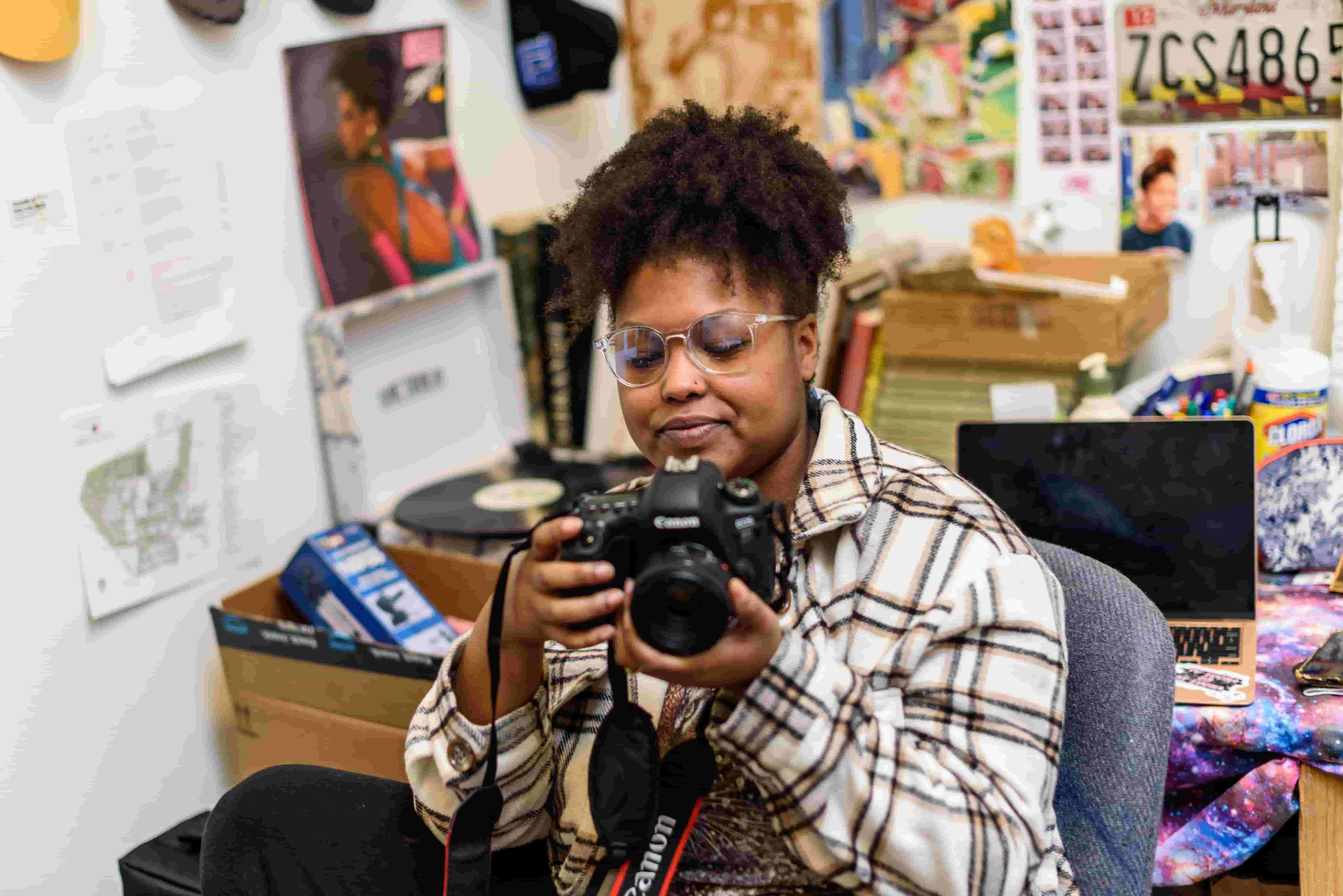 Student with camera and record-player in studio.