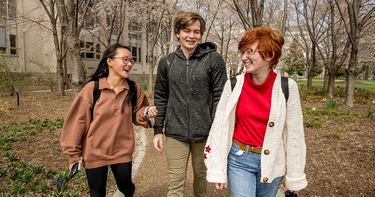 Three students chat amicably