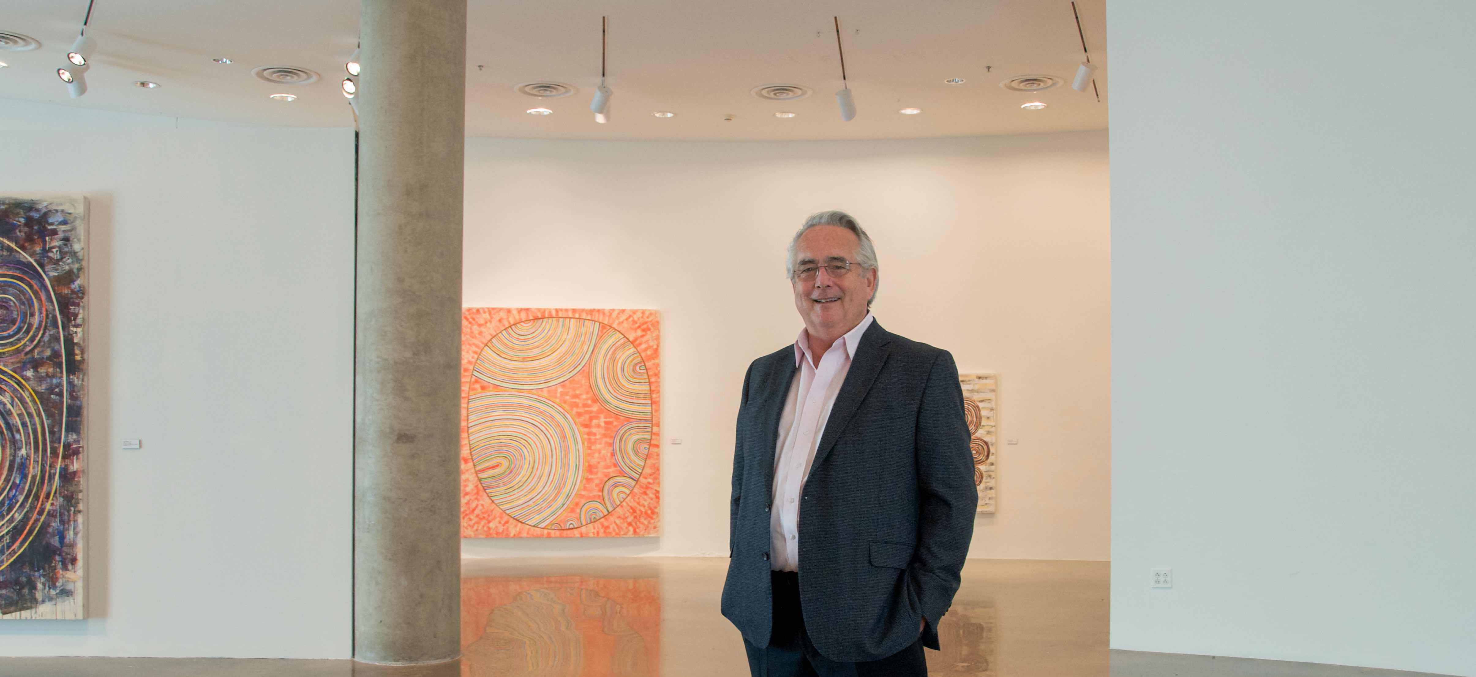 Jack Rasmussen standing among artworks in the AU Museum in Katzen Performing Arts Center.