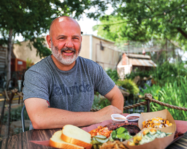 Matthew Odam sits outside before a big plate of food