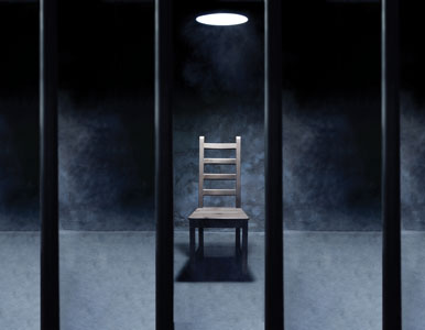 an empty interrogation chair in a prison cell