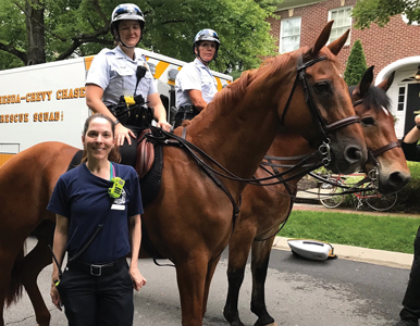 EMT Maryam Tabrizi in front of two police officers on horseback