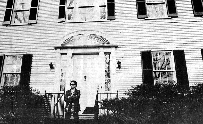 African American student with arms crossed outside the President's Office Building