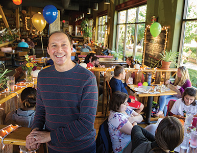 Lenard Zohn in a restaurant with children and balloons