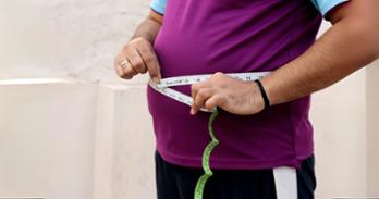 A person is measuring his belly circumference