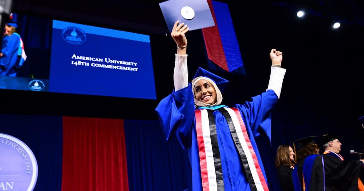 A member of AU's Class of 2024 celebrates after collecting her diploma