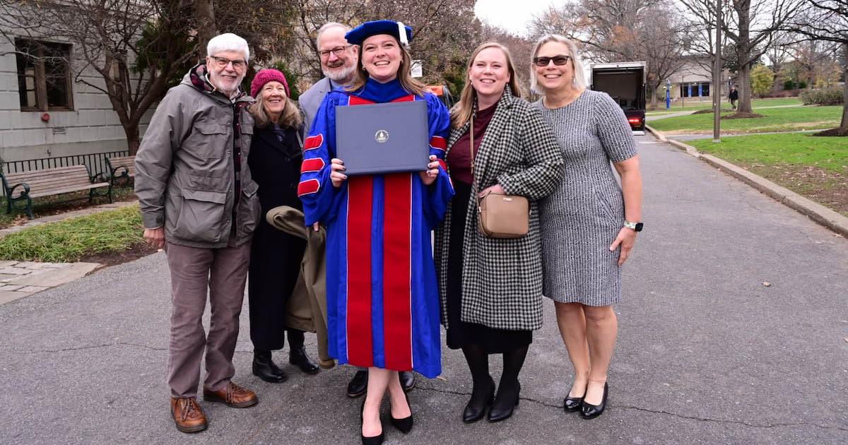 WCL graduate from the Class of 2024 smiles with her family on the quad