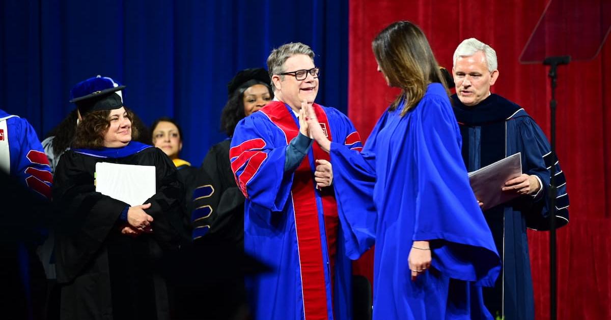 Sean Astin high-fives a student while President Jon Alger looks on