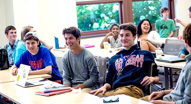 group of laughing students in an SIS classroom that participated in the Community of Scholars program