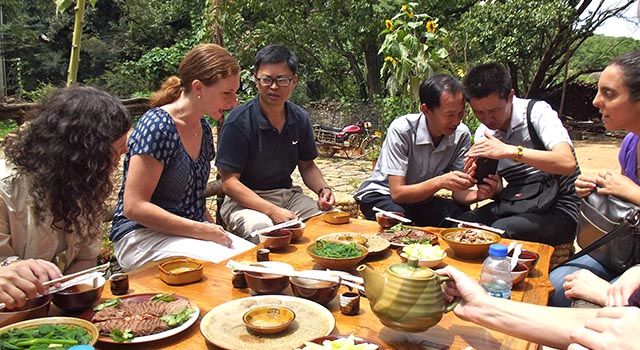 Program Director Amanda Taylor at table with practicum students and local associates in China