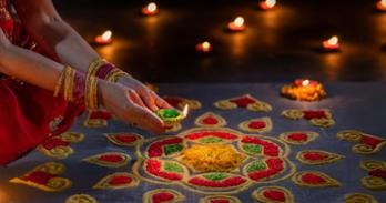 A woman holds a candle toward a decorative table