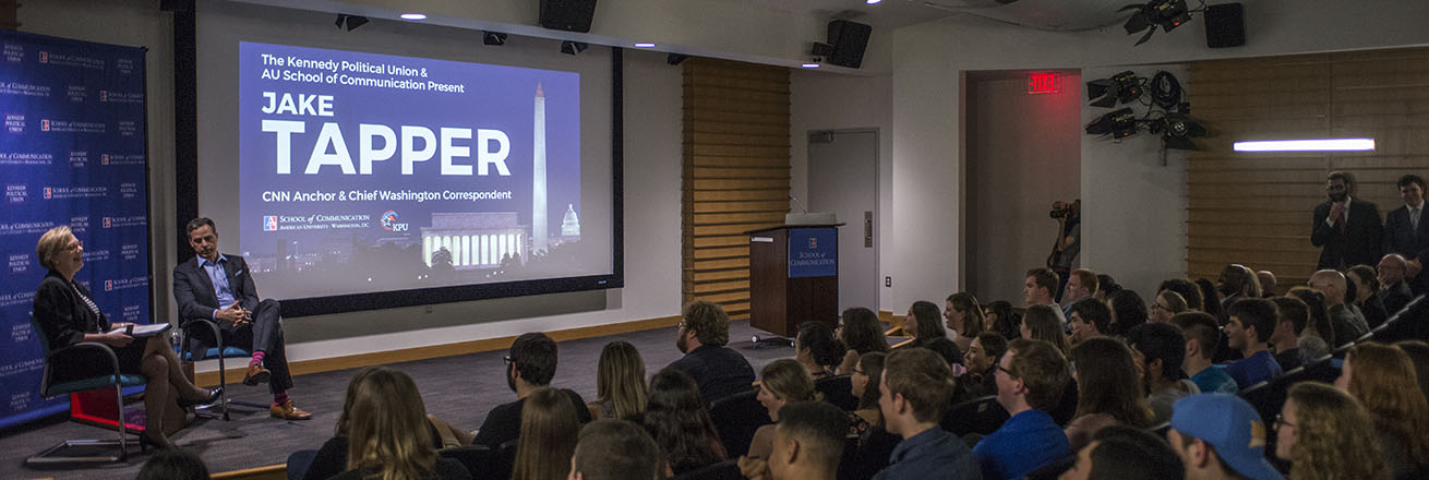 CNN Anchor Jake Tapper and SOC professor Jane Hall speak in front of an audience of students.