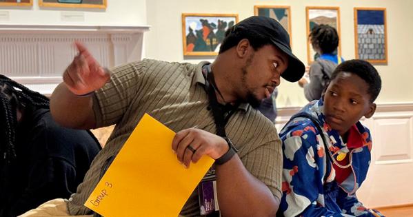 Student Charles Dixon points to a painting to teach a student during a Community-Based Experience at The Phillips Collection.