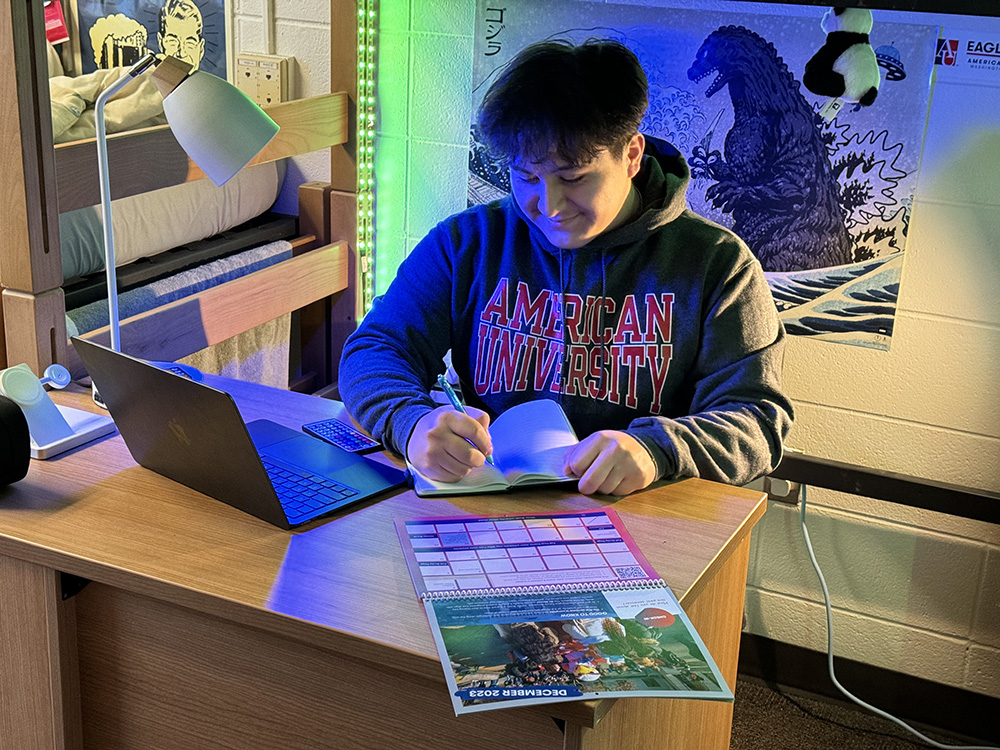 Luis Paredes works at his desk in his residence hall.