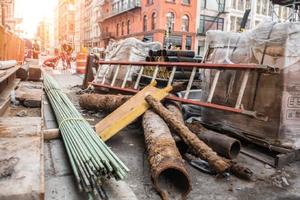 Pile of lead pipes in garbage heap in urban setting.