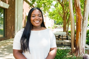 Washington Semester alumna Maya Peebles poses underneath a canopy of trees