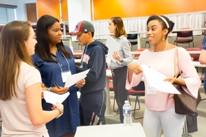 Three young women converse happily with one another.