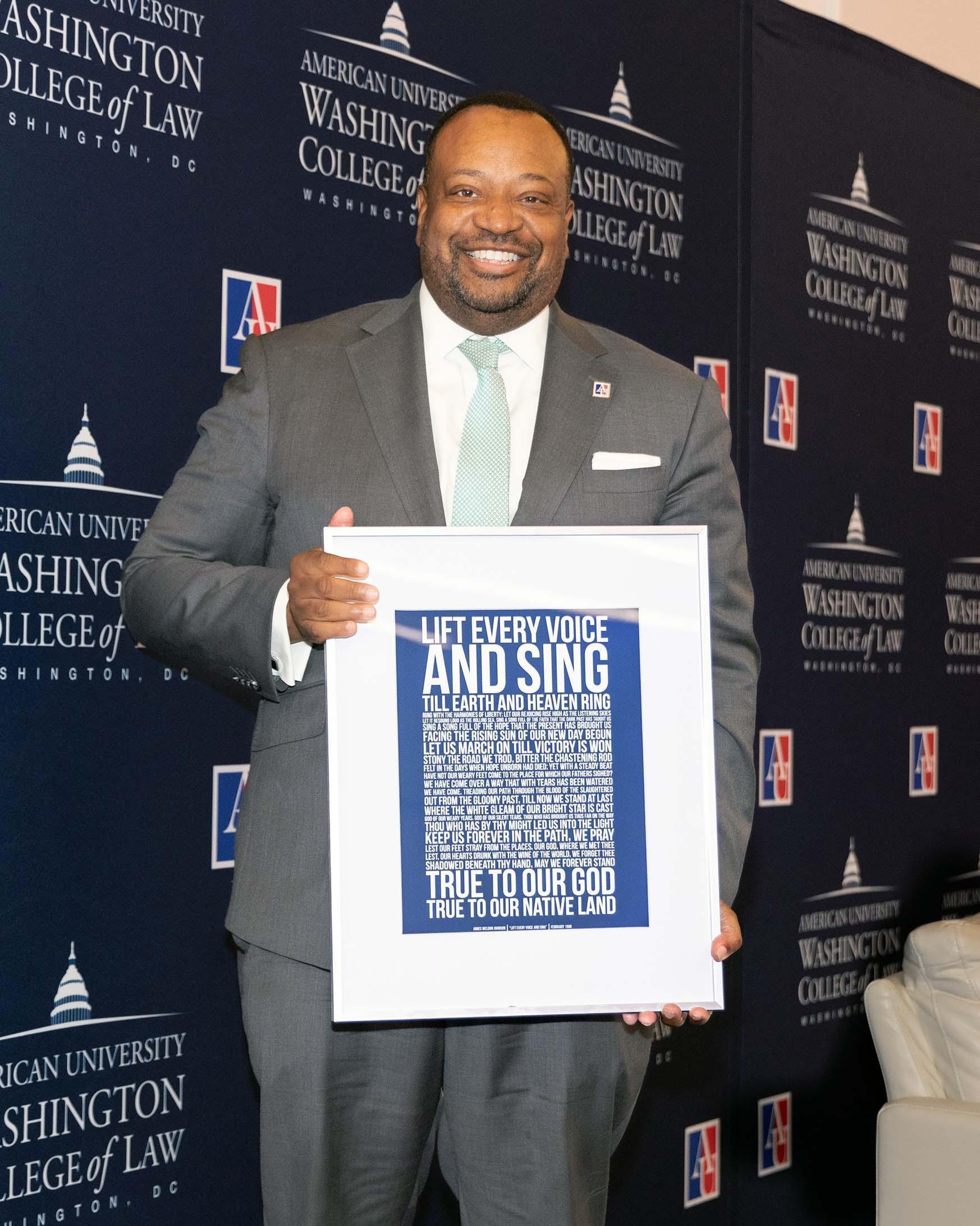 Dean Fairfax with a framed copy of the Black National Anthem, "Lift Every Voice."